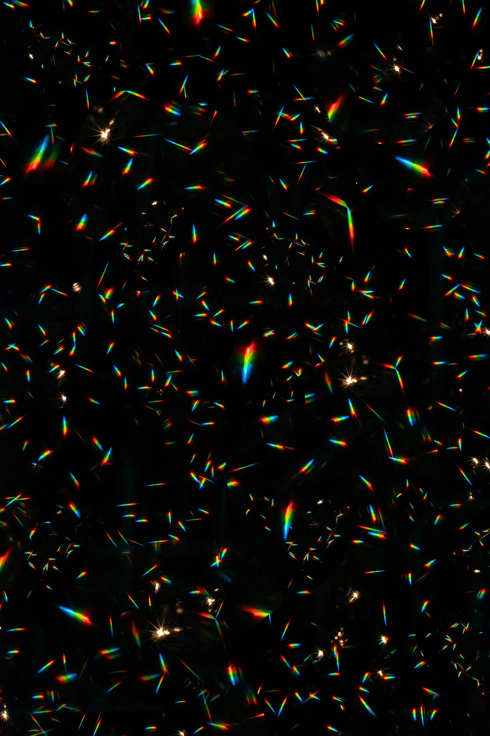 A display of rainbow light reflections with an otherwise pitch black background.  